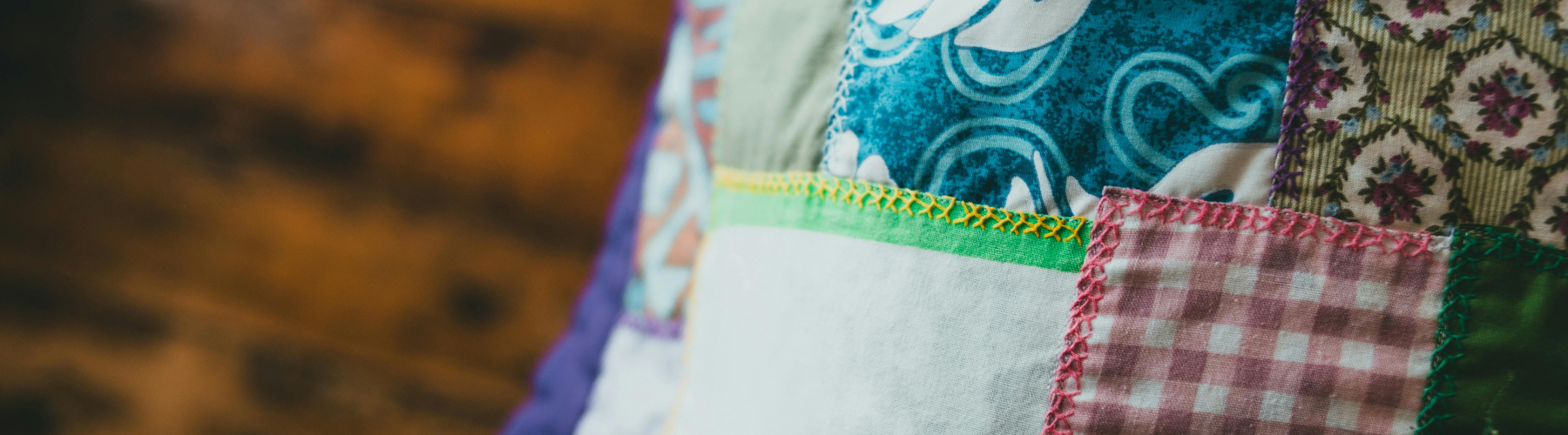 A close-up of colorful patchwork fabrics and decorative hand stitching